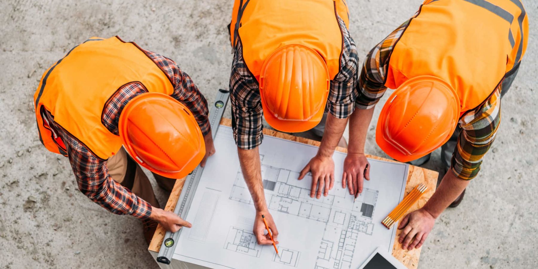 high angle view of group of builders discussing building plan at construction site
